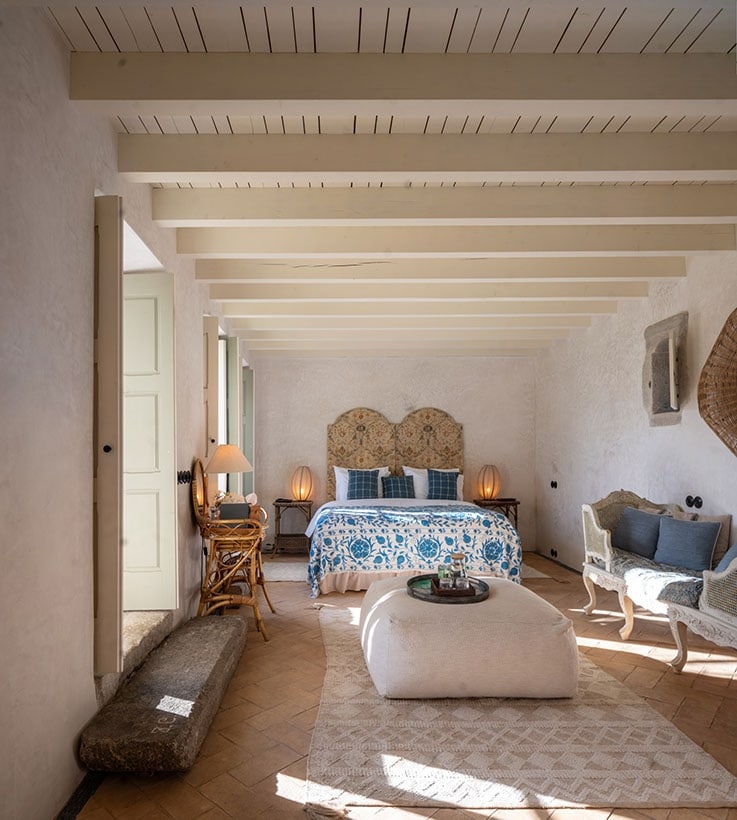 A restored suite with beamed ceiling and antique linens